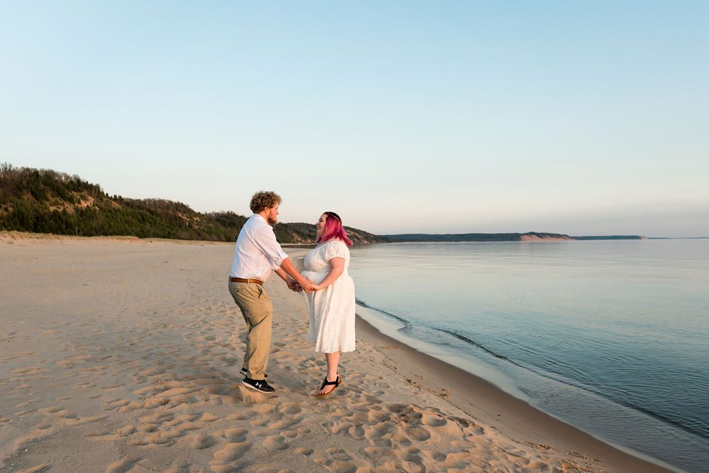 a couple jumps up and down at Elberta beach.