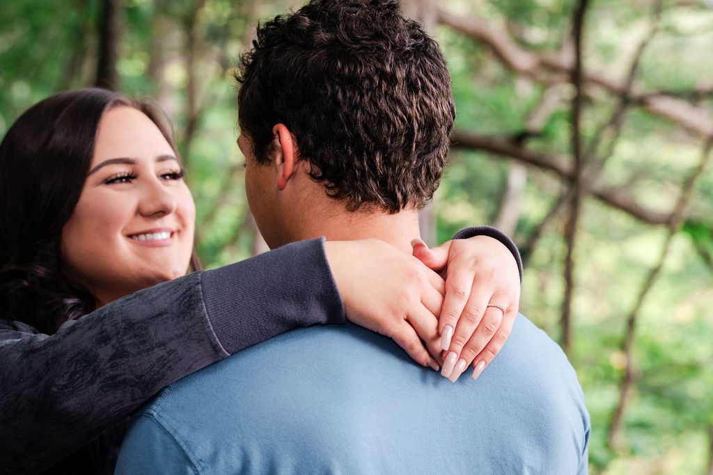 a woman looks lovingly into the eyes of her fiancé at the high rollaway trail for engagement photos. 