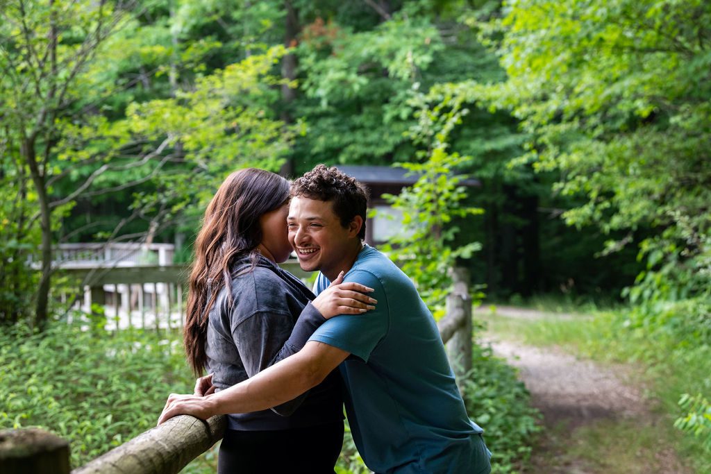 Montana leans into his fiancé and laughs as she whispers into his ear for engagement adventure.