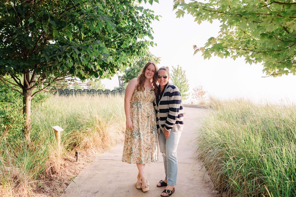 A graduating senior poses with her mom during senior portraits at camp arcadia.