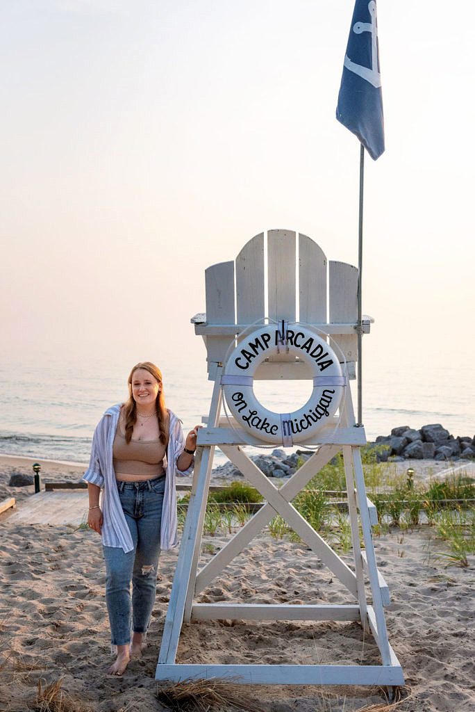 a senior portrait of a girl standing next to the life guard chair at Camp Arcadia.