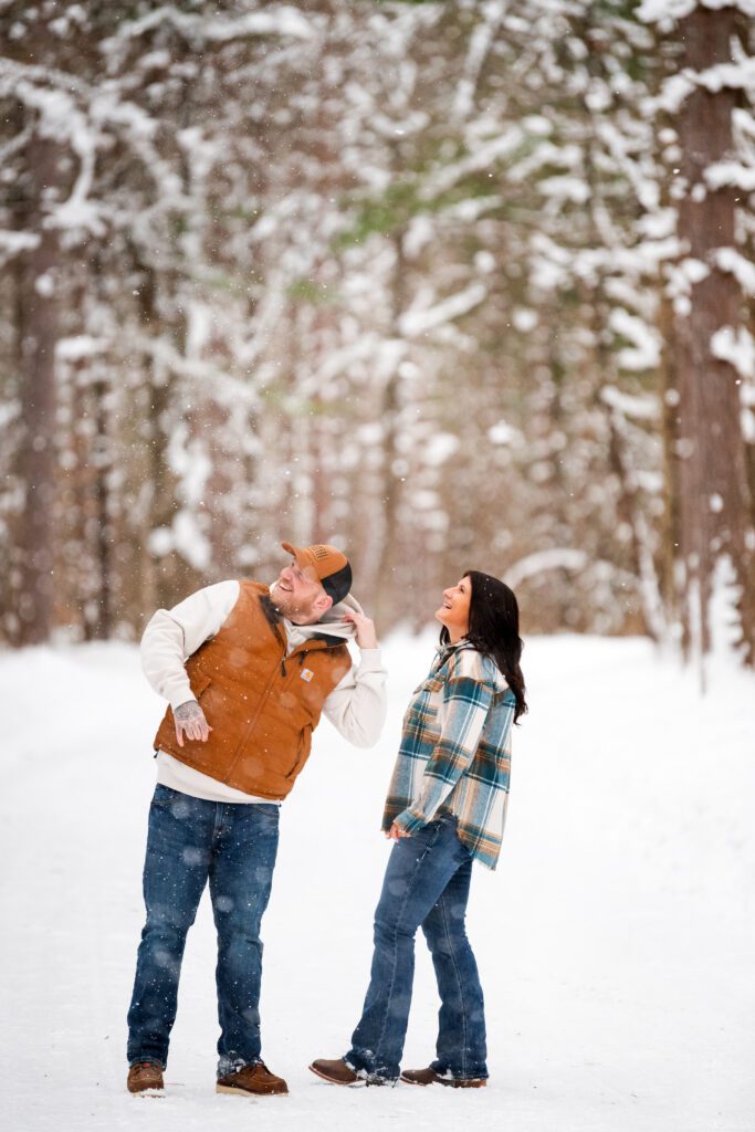 snow falls on an engagement couple at Northern Exposure campground in Mesick, MI.